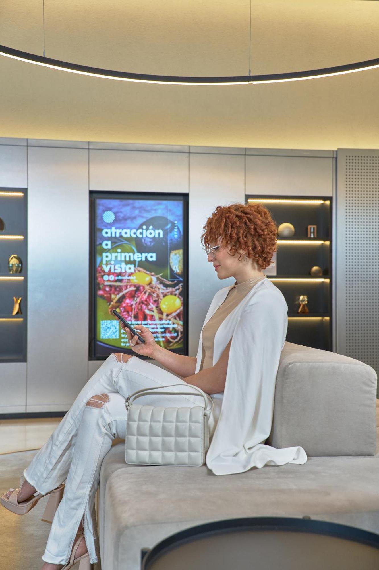 Pullman Santiago Vitacura Ngoại thất bức ảnh A woman using a mobile phone to interact with a digital signage display